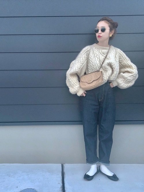 白いセーターにデニムを穿いた女性
